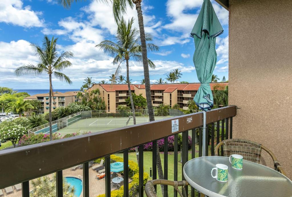 a balcony with a table and a tennis court at Maui Vista by Coldwell Banker Island Vacations in Kihei