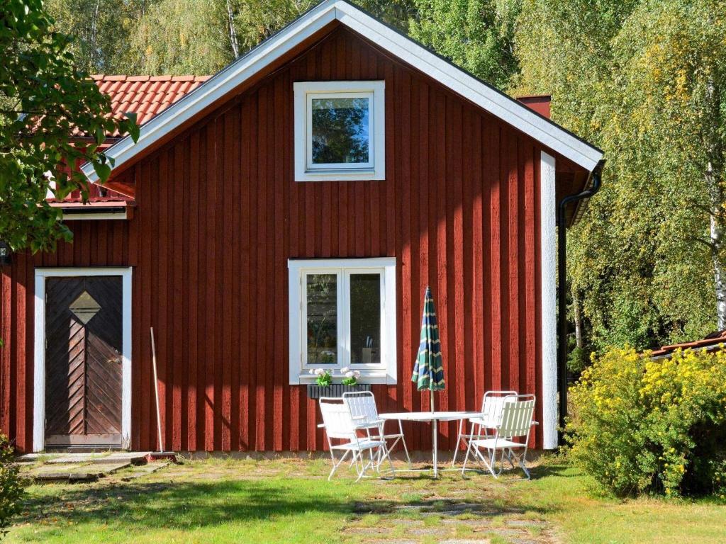 a red house with a table and chairs in front of it at 3 person holiday home in HAMMARÖ-By Traum in Hammarö