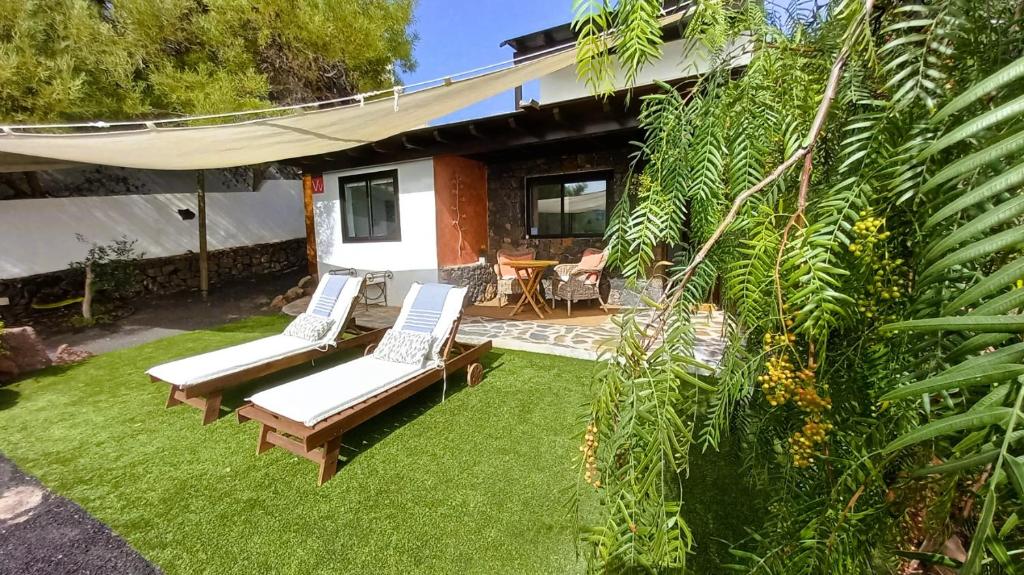 a patio with two chairs and a table in a yard at Ocean View in Playa Blanca