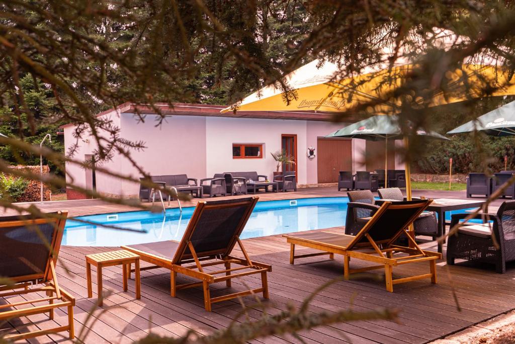 un grupo de sillas sentadas junto a una piscina en Penzion Tadeášovy domky, en Hajnice