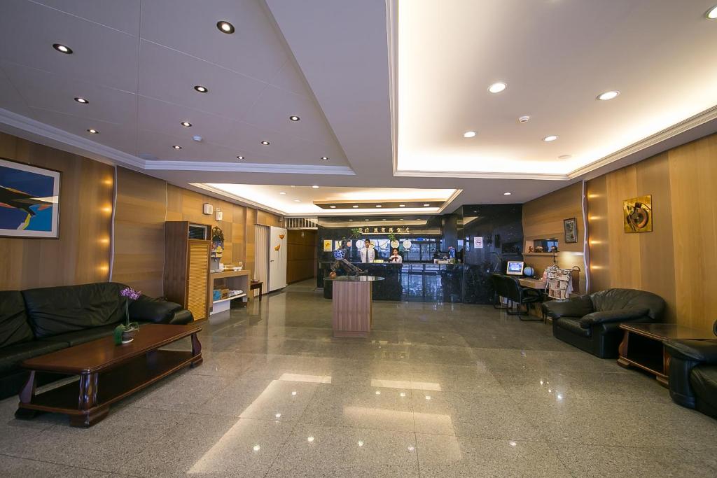 un vestíbulo con sofás y un bar en una tienda en Jiuning Business Hotel en Tainan