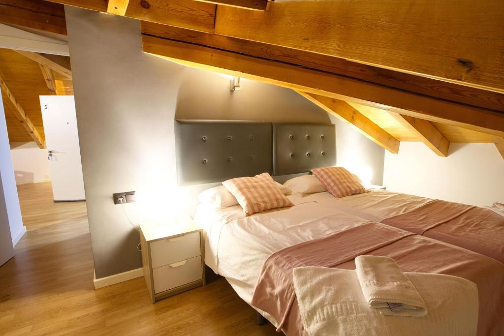 クエンカにあるCuencaloft La Plazetaのベッドルーム1室(屋根裏部屋に大型ベッド1台付)