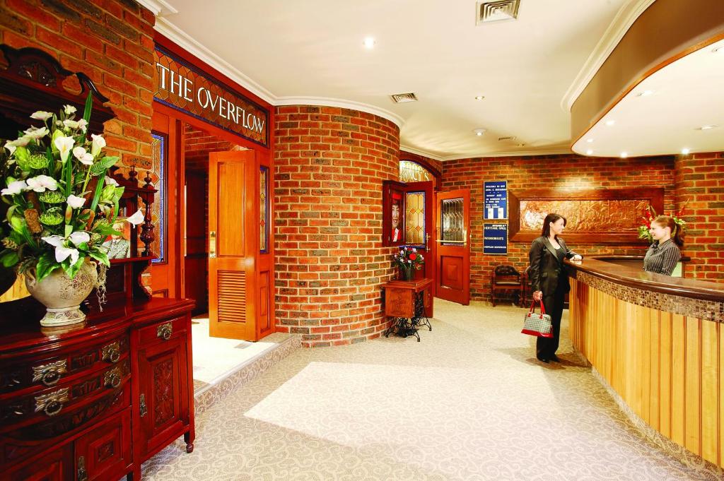 a woman standing at the counter of a hair salon at Hotel Bruce County in Mount Waverley