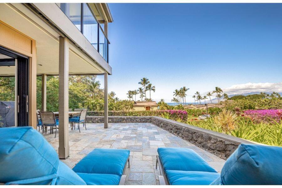 a patio with blue couches and a table and chairs at WAILEA ELUA, #2501 condo in Wailea