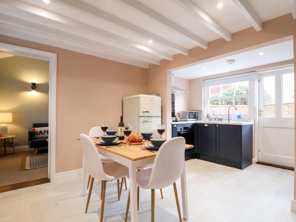 eine Küche und ein Esszimmer mit Tisch und Stühlen in der Unterkunft Poppy Cottage in Southwold