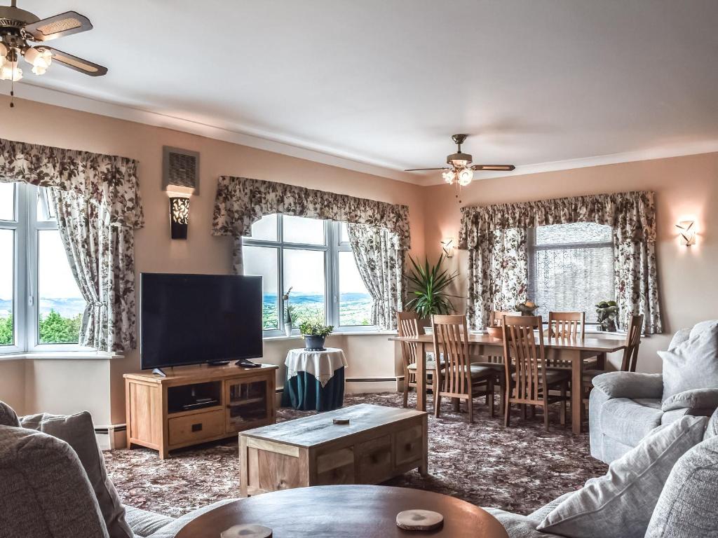 a living room with a television and a dining room at Scotch Pine in Bettws
