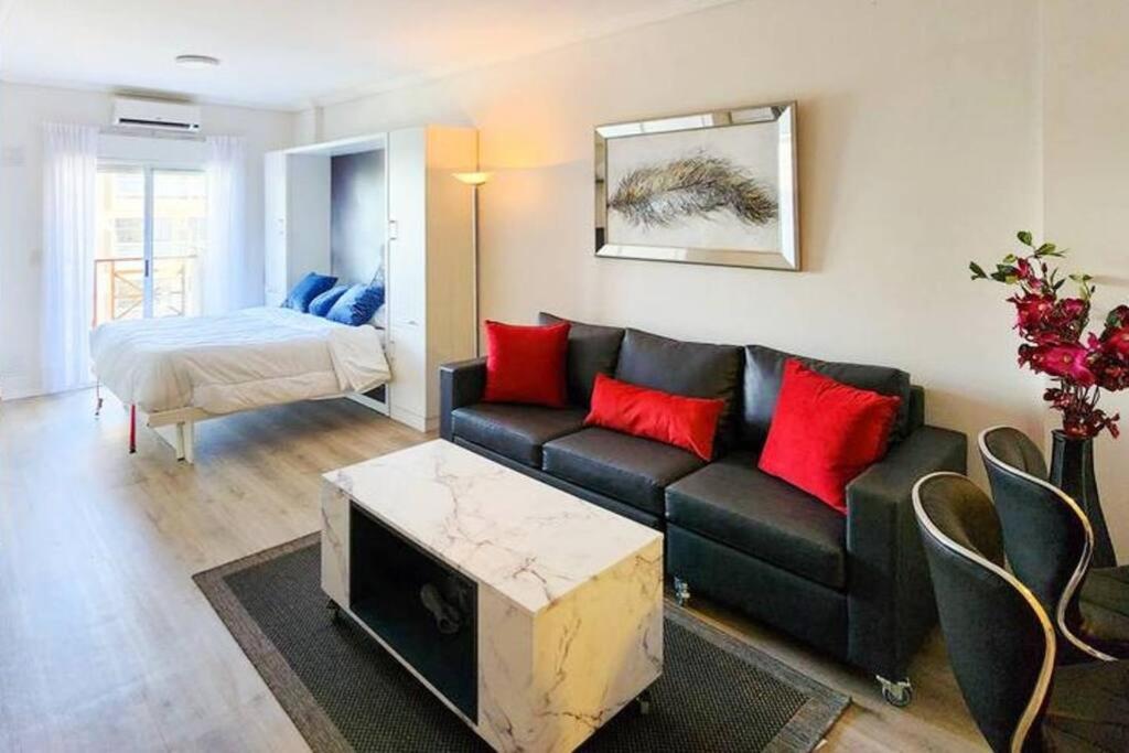 ブエノスアイレスにあるSmart Design Home - Buenos Airesのリビングルーム(黒いソファ、赤い枕付)