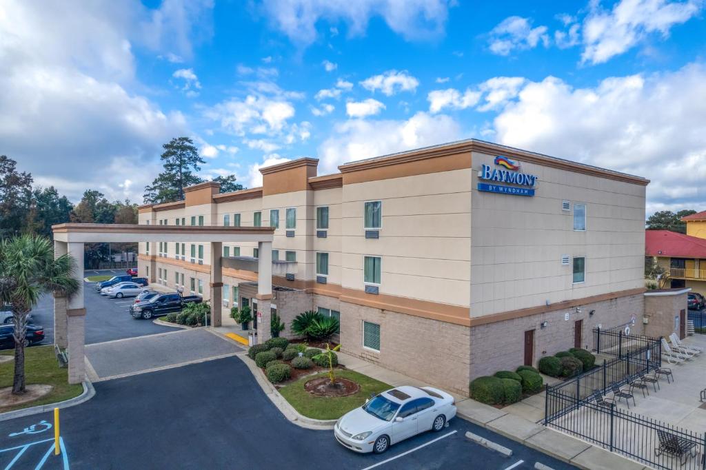 un hotel exterior con un coche aparcado en un aparcamiento en Baymont by Wyndham Savannah South, en Savannah