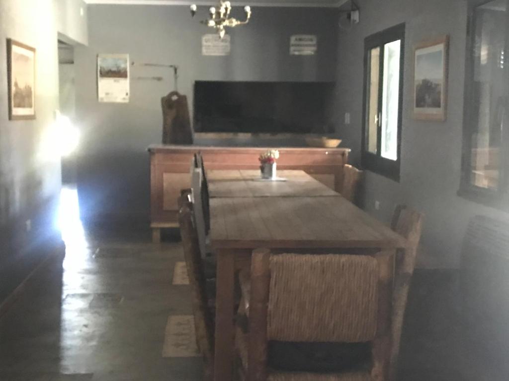 comedor con mesa de madera y piano en Casa rural familiar con pileta en Arrecifes