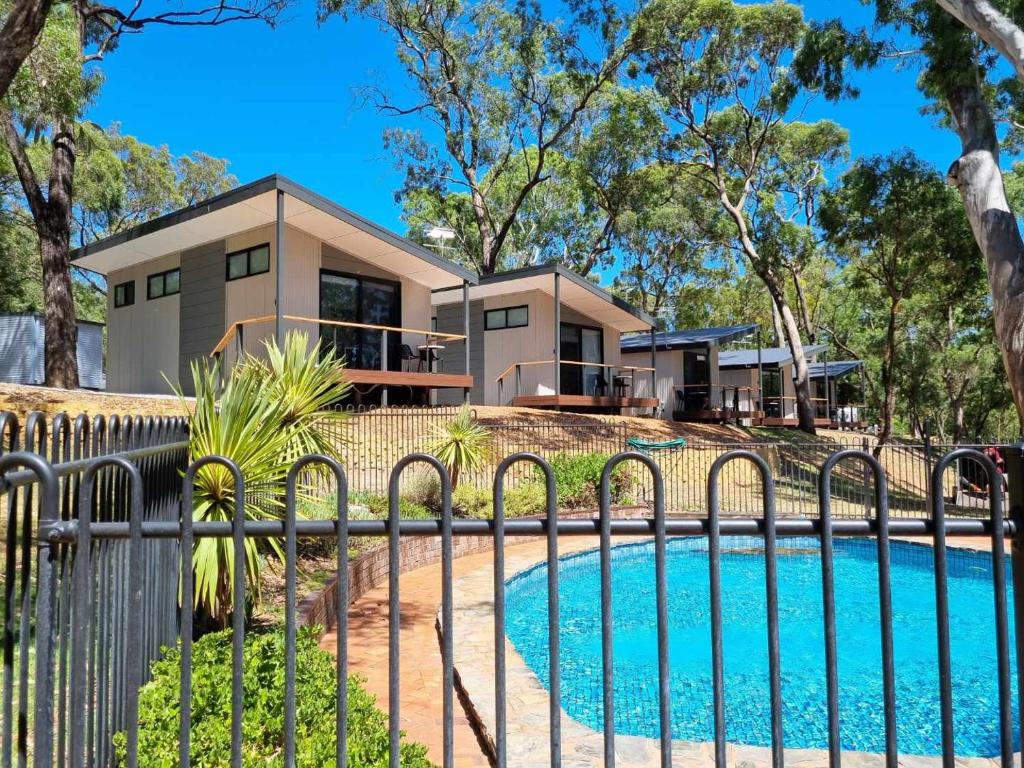 a house with a fence around a swimming pool at Belair National Park Holiday Park in Belair