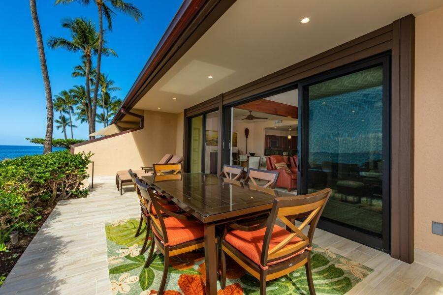 a dining room with a table and chairs and the ocean at MAKENA SURF, #G-101 condo in Wailea