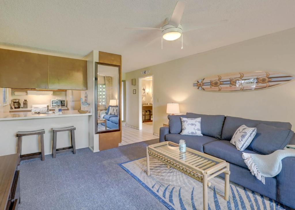 a living room with a blue couch and a table at Kauai Plantation Hale Suites by Coldwell Banker Island Vacations in Kapaa