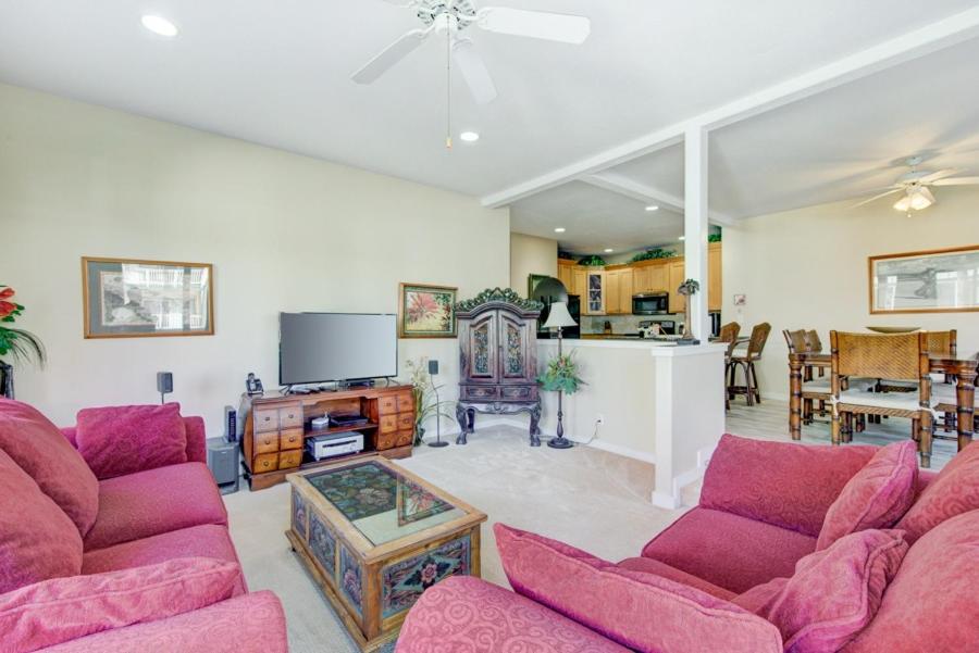 a living room with purple couches and a kitchen at Kauai Regency at Poipu Kai by Coldwell Banker Island Rentals in Koloa