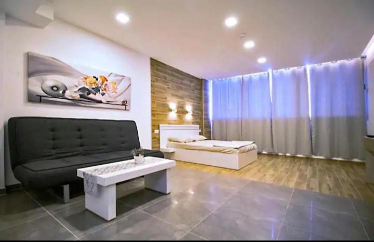 uma sala de estar com um sofá e uma mesa de centro em BRiGHT AND COZY STUDIO SUiTE EiLAT em Eilat