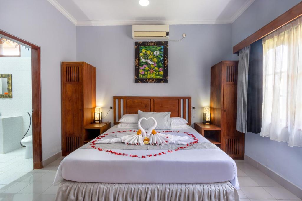 a bedroom with a bed with a flower arrangement on it at Bon Nyuh Bungalows in Gianyar