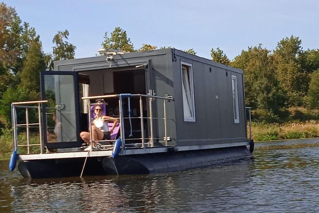 Dziewczyna siedzi na małej łodzi w wodzie. w obiekcie Dom na wodzie z tarasem w Warszawie