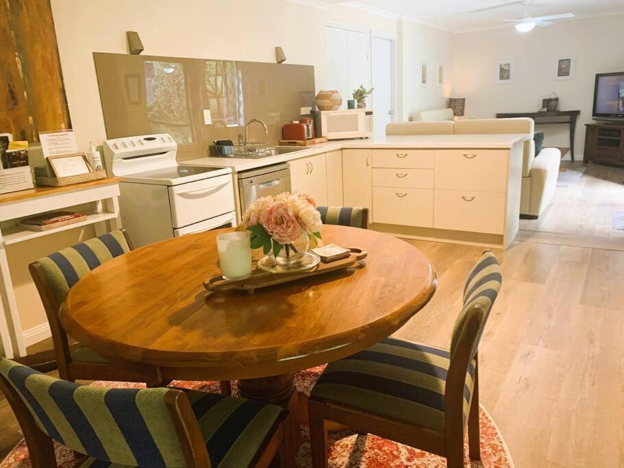 una cocina con una mesa de madera con sillas y una mesa sidx sidx sidx sidx en Cloudland Garden Oasis, en Blackheath