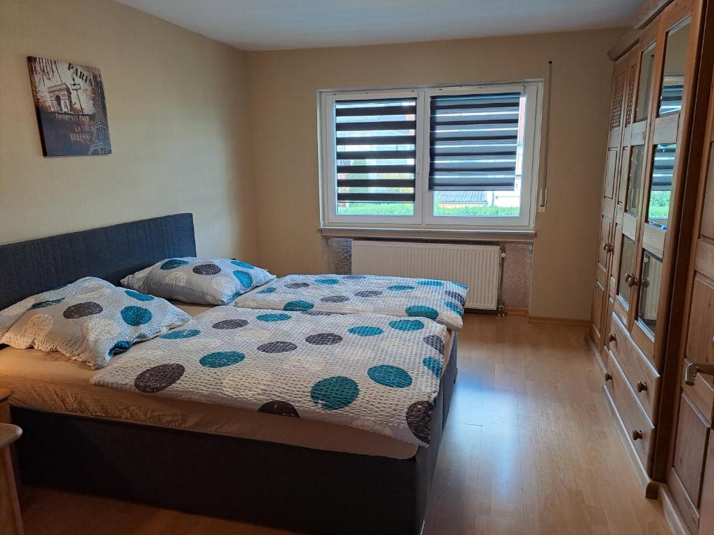 a bedroom with a bed and a window with blinds at Ferienwohnung Schleiten 2 in Püttlingen