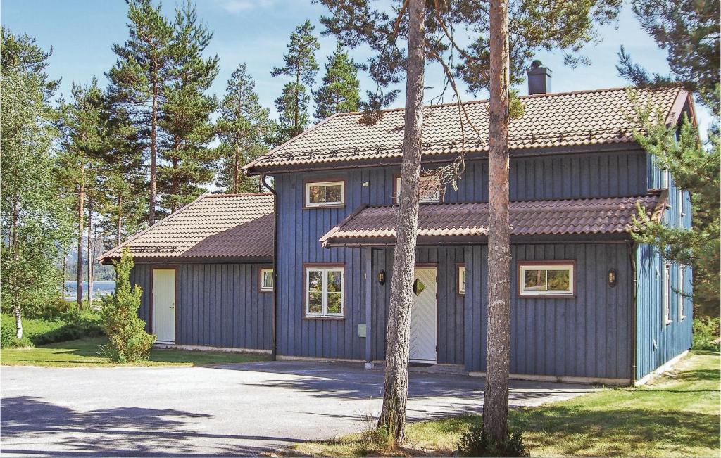a blue house with a garage and trees at Hytte 1 in Øvre Ramse