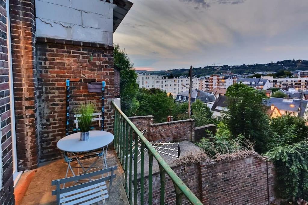 a balcony with a table and a view of a city at Superbe Studio 2 *Face Gare * Belle Vue Sur Balcon in Évreux