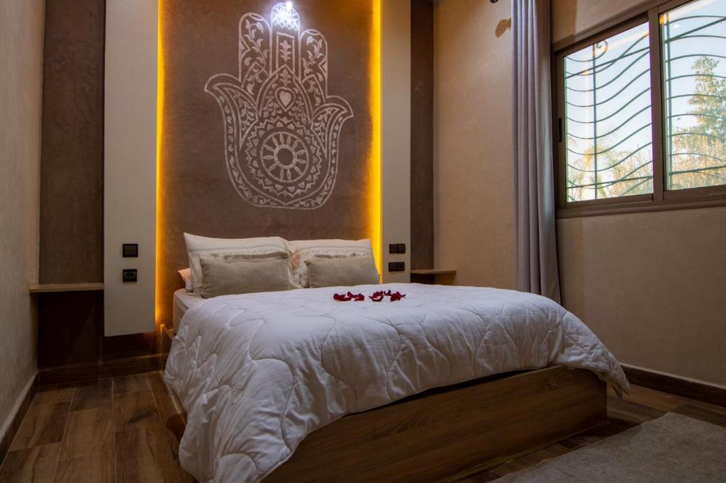 - une chambre dotée d'un lit avec des bougies rouges dans l'établissement La ferme, à Marrakech