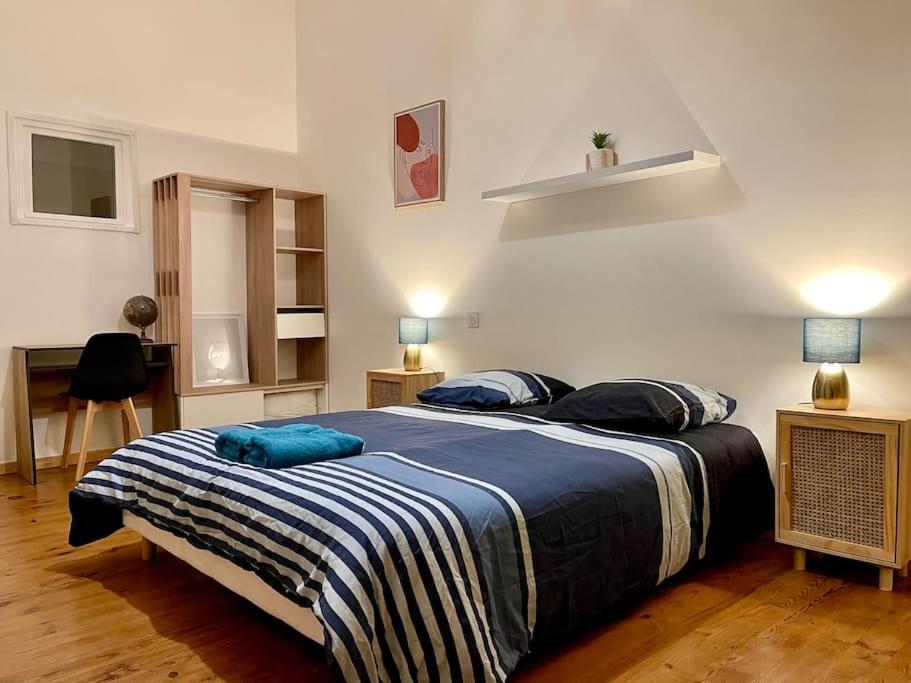 une chambre avec un grand lit avec des oreillers bleus dessus dans l'établissement Appartement confort - Carcassonne centre, à Carcassonne