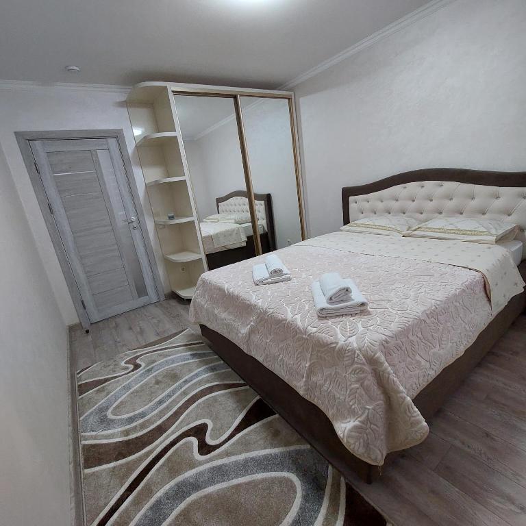 a bedroom with a large bed and a mirror at Apartament lux new in Chişinău