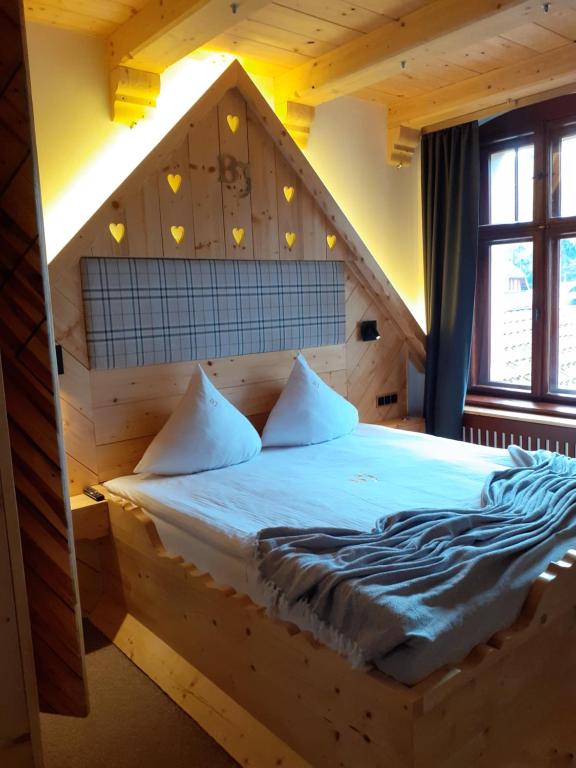1 dormitorio con cama de madera en una habitación en Rezydencja Biały Jar, en Karpacz