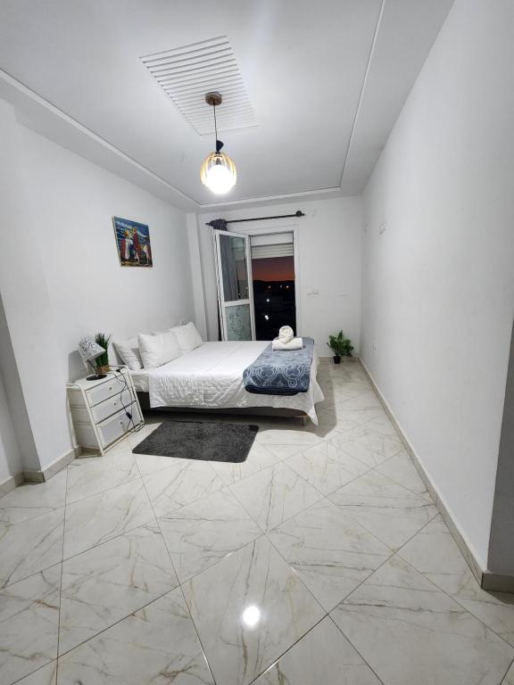 a bedroom with a bed in a white room at FamilyConfort Saidia in Saïdia