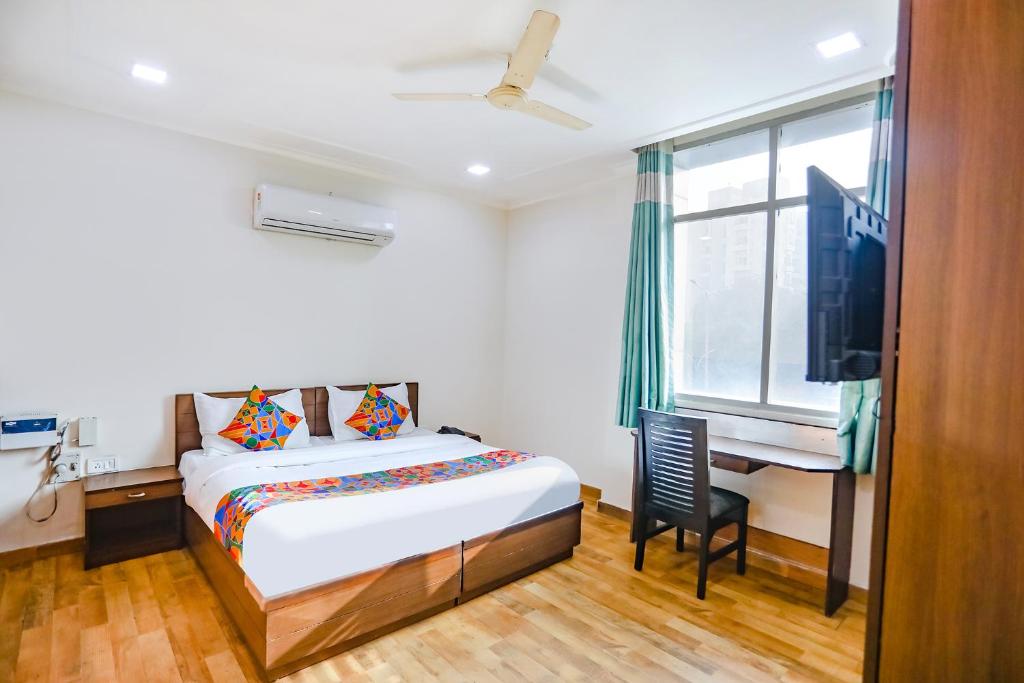 Schlafzimmer mit einem Bett, einem Schreibtisch und einem TV in der Unterkunft FabHotel Hexa Ghaziabad in Ghaziabad