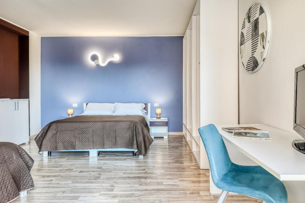 1 dormitorio con cama y pared azul en Asso Residence, en Terni