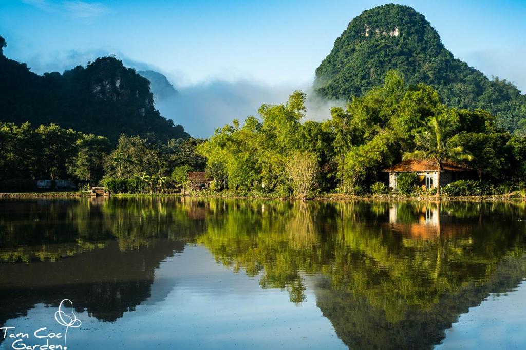 vistas a un lago con montañas en el fondo en Tam Coc Garden Resort, en Ninh Binh