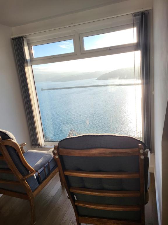 una ventana en una habitación con una silla delante en Seasidesteps, en Fishguard