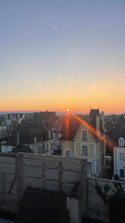 a sunset over a city with the sun setting at Deauville Harmonie - Tout à pied, Balcon &amp; Modernité in Deauville