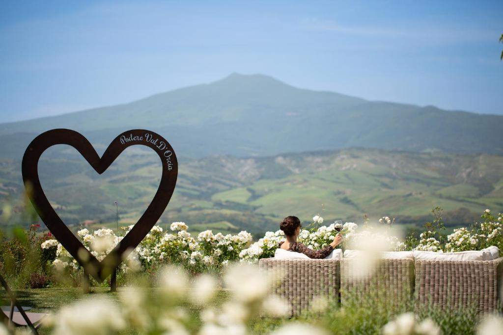 a woman sitting on a table with a heart sign at Podere Val D'Orcia - Tuscany Equestrian in Sarteano