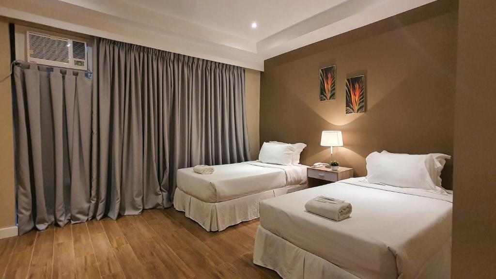 a hotel room with two beds and a window at Villa Verde Guest House in General Santos