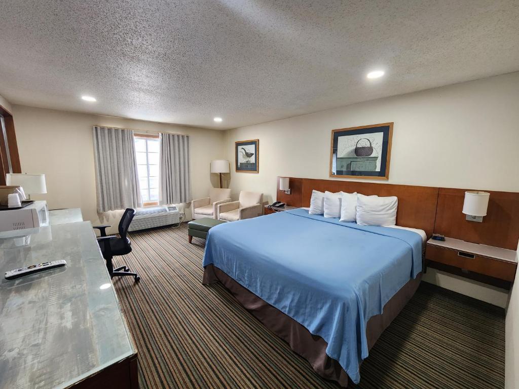 普雷里申的住宿－溫莎廣場酒店，配有一张床和一张书桌的酒店客房