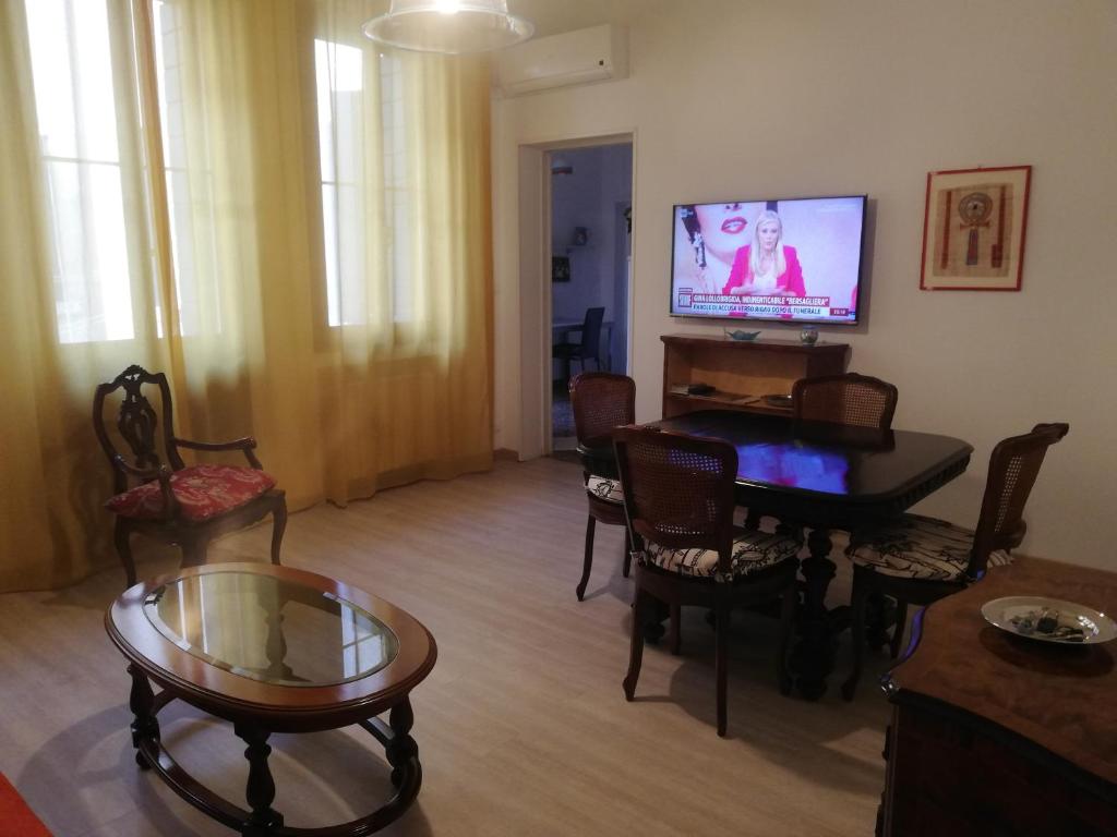 salon z telewizorem, stołem i krzesłami w obiekcie Laura w Wenecji