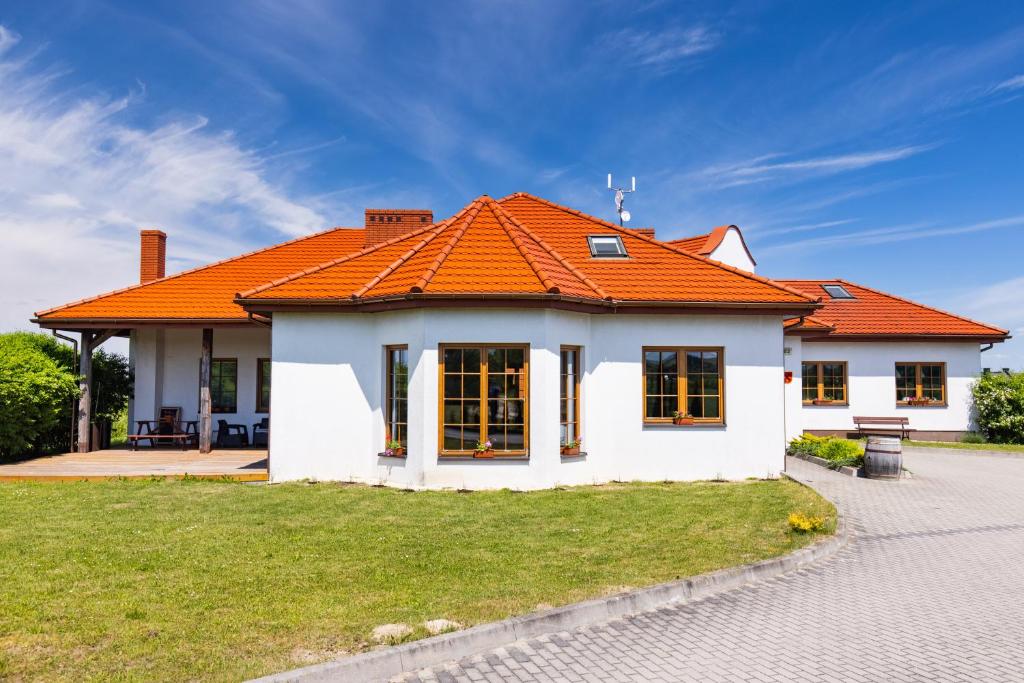 Biały dom z pomarańczowym dachem w obiekcie Winnica Zbrodzice w Busku Zdroju