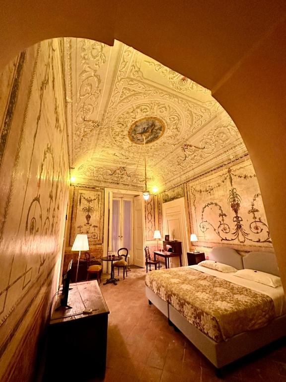a bedroom with a bed with an ornate ceiling at Casa Santangelo Suites in Salerno