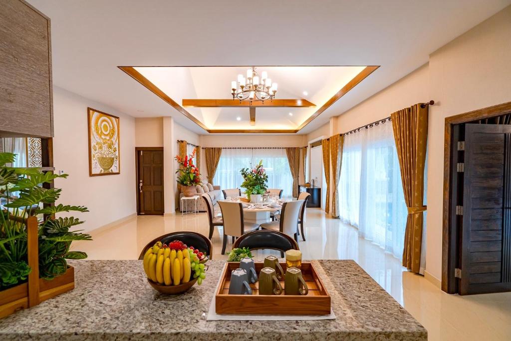 a living room with a table and a dining room at Silverlake Oasis : Pool Villa in Na Jomtien