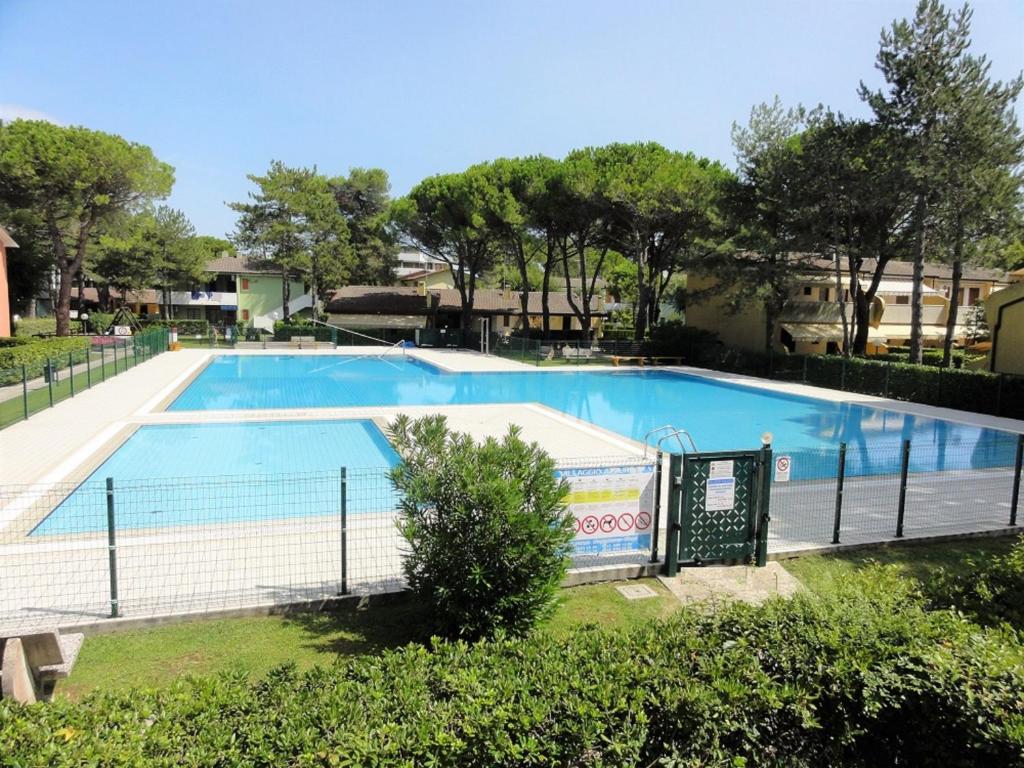 een groot zwembad met een hek eromheen bij Villaggio Azzurro Plus in Bibione