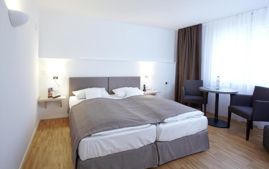 um quarto com uma cama grande, uma mesa e cadeiras em Hotel Klingelhöffer em Alsfeld