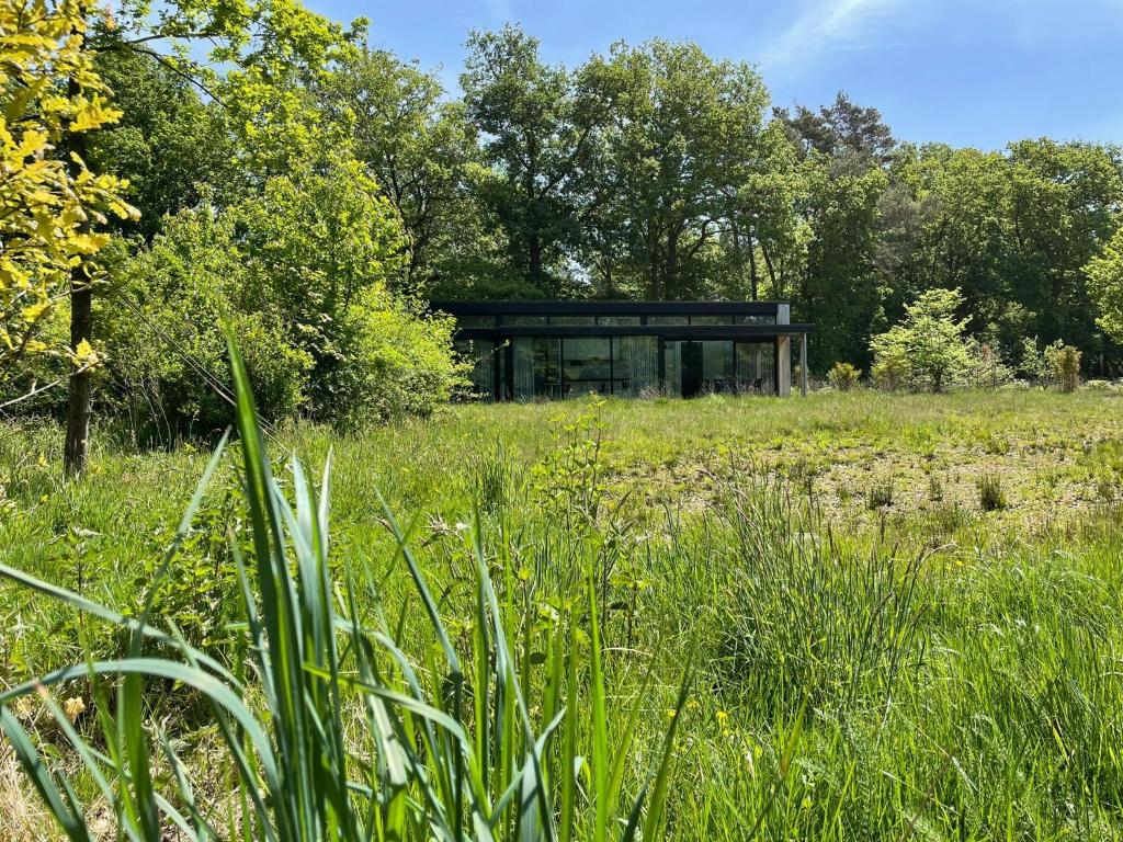 een glazen gebouw in het midden van een veld bij Olde Kottink in Beuningen