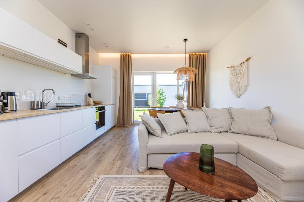 a living room with a white couch and a table at 360 Apartments in Užpelkiai