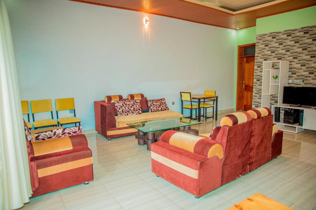 Il comprend un salon avec des canapés et une télévision à écran plat. dans l'établissement Leisure Safaris and Inns, à Ruhengeri