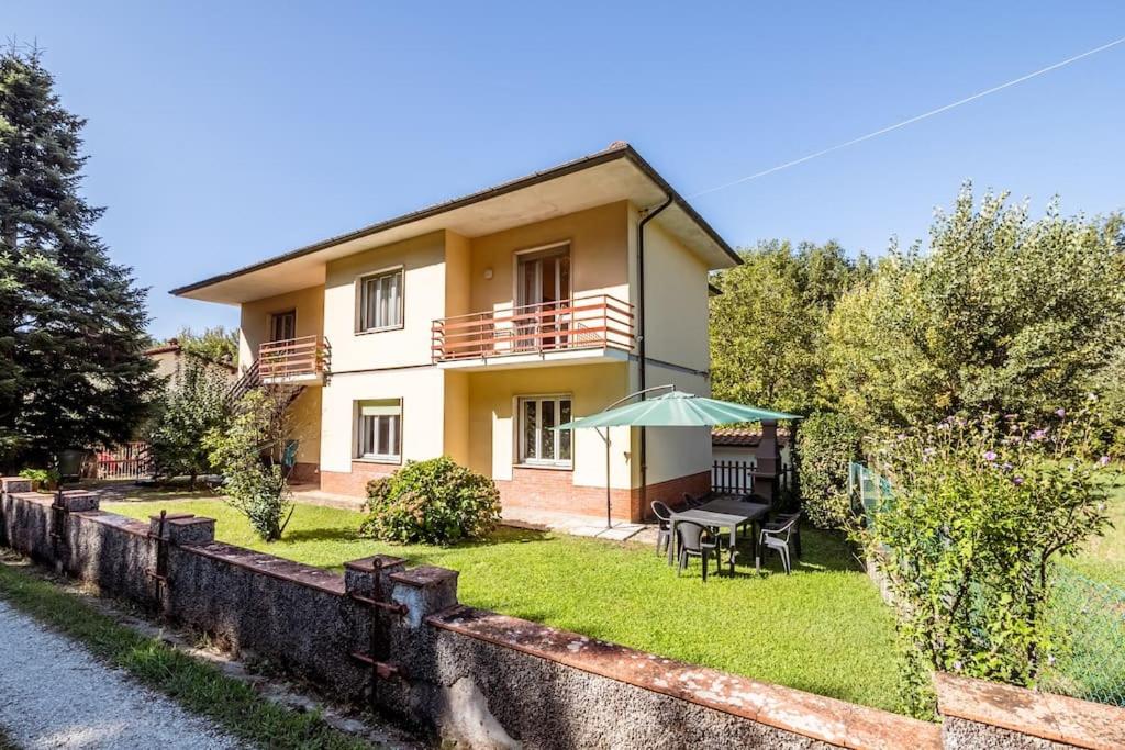 a house with a yard with a table and chairs at Appartamento Poggio del Sole in Lucca