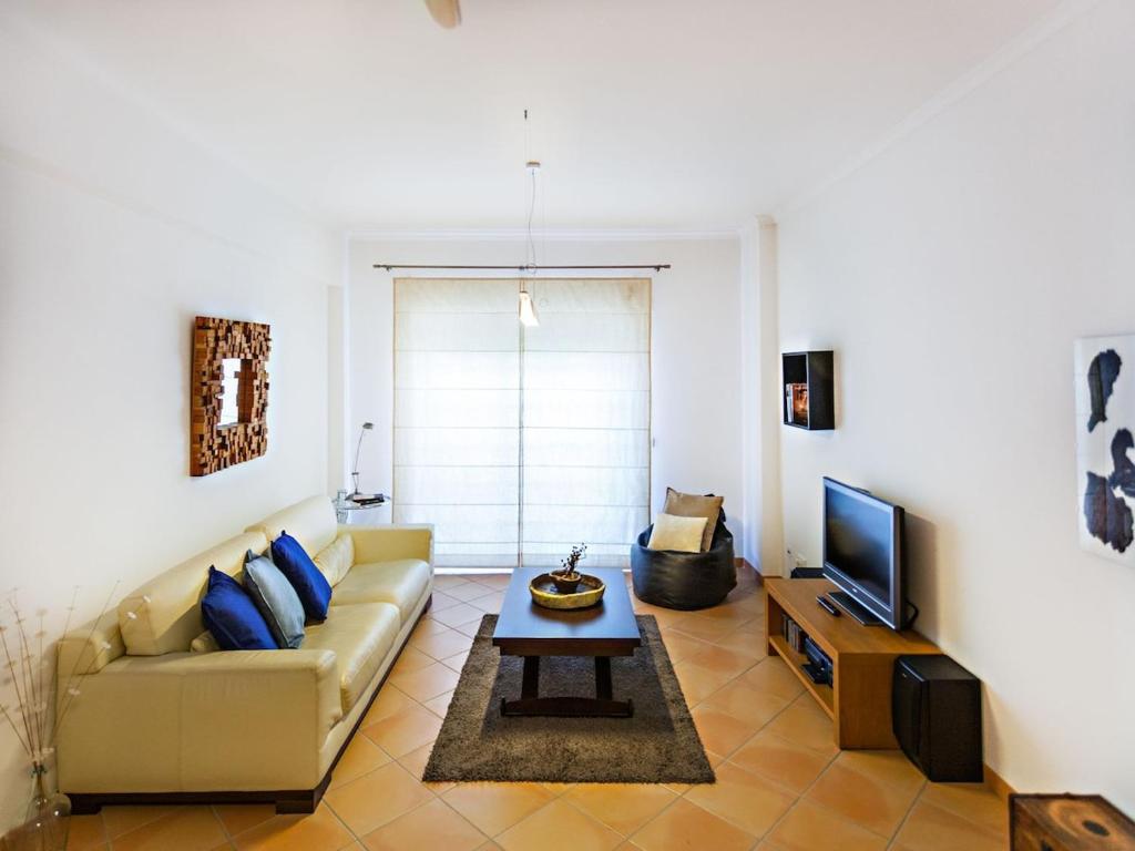 a living room with a couch and a tv at Alameda Apartment in Faro