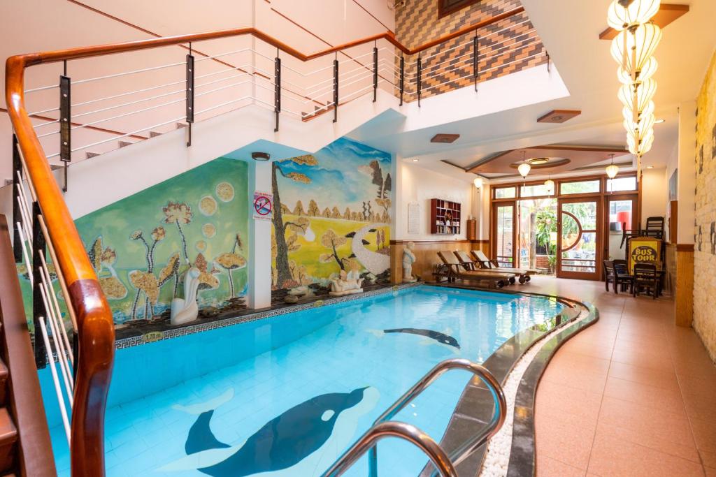 a pool in a house with a dolphin swimming at Hoa My II Hotel in Hoi An