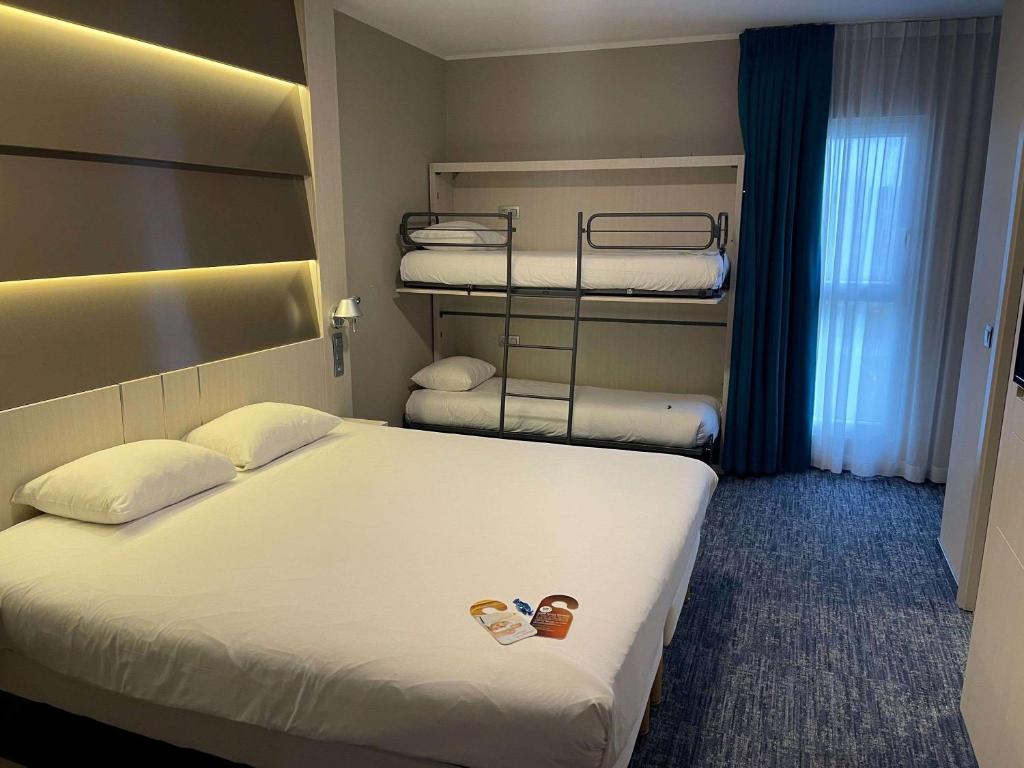 a hotel room with a bed and bunk beds at ibis Styles Nivelles in Nivelles